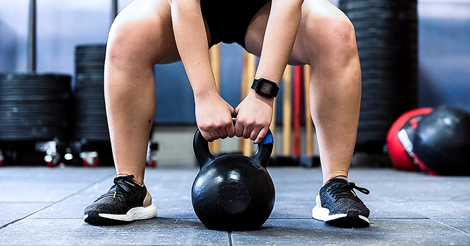 Someone lifting a heavy kettlebell off the floor | Trainest
