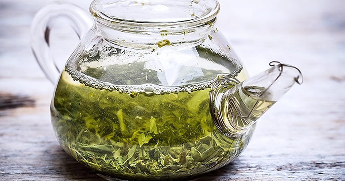 A transparent glass pot of green tea | Trainest 