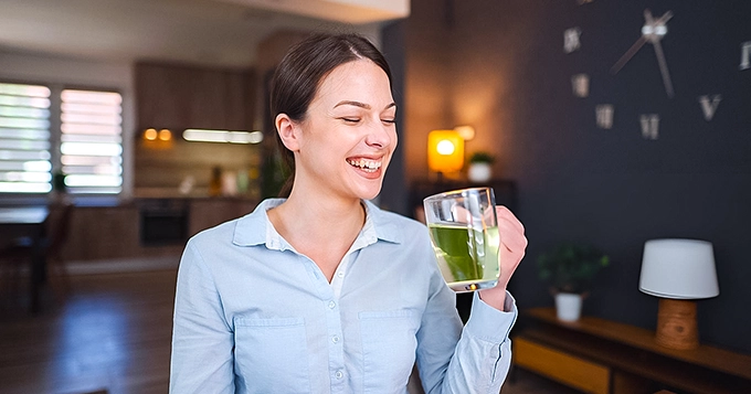 A woman drinking green tea at home | Trainest 