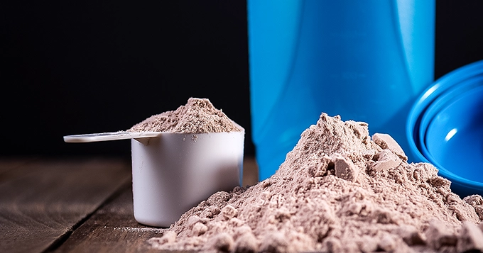 A scoop of protein powder and a shaker bottle | Trainest 