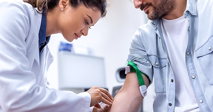 A man getting his blood drawn by a doctor | Trainest
