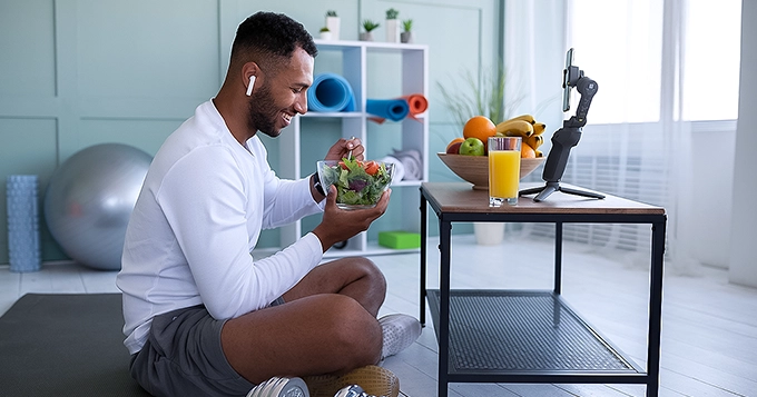 A fit man eating a veggie salad | Trainest 