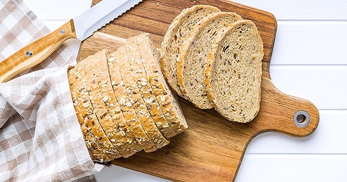 A loaf of whole grain bread on a cutting board | Trainest
