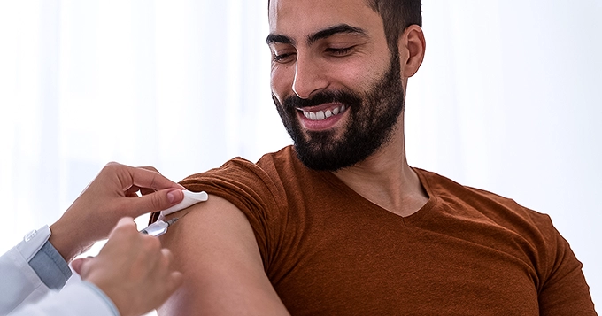 A man getting injected on his arm by a medical professional | Trainest 