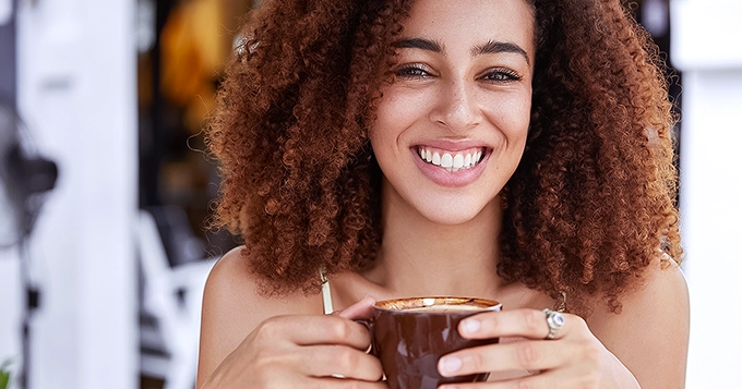 A woman enjoying a cup of hot chocolate | Trainest 