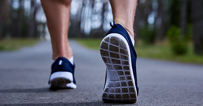 A close-up of the feet of a person walking in the park | Trainest 