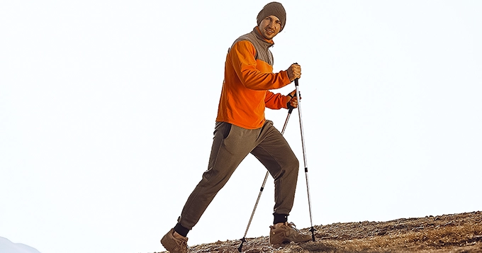 A man using Nordic walking poles while hiking | Trainest 