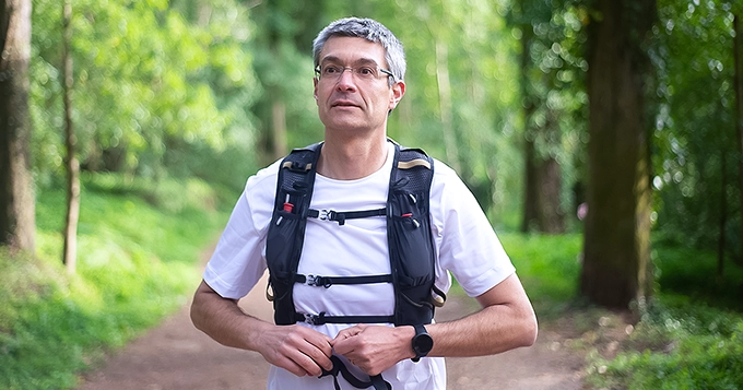 A man wearing a hydration vest while walking outdoors | Trainest 