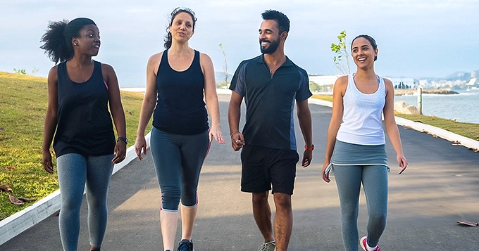 A group of people walking together in the park | Trainest 