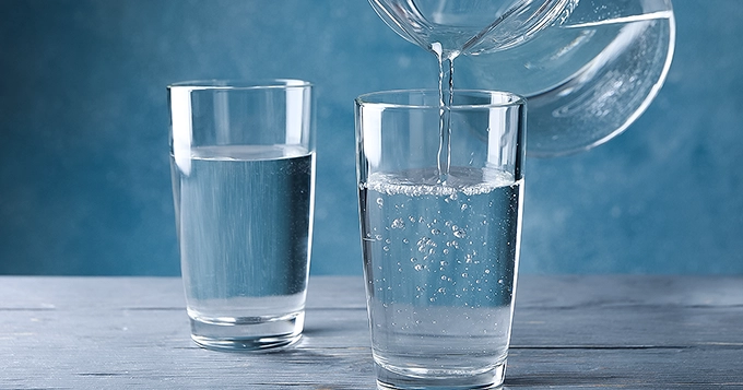 Two glasses and a pitcher of water being poured | Trainest
