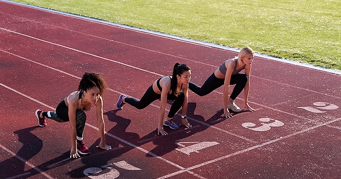 A group of runners on the starting line of a track | Trainest
