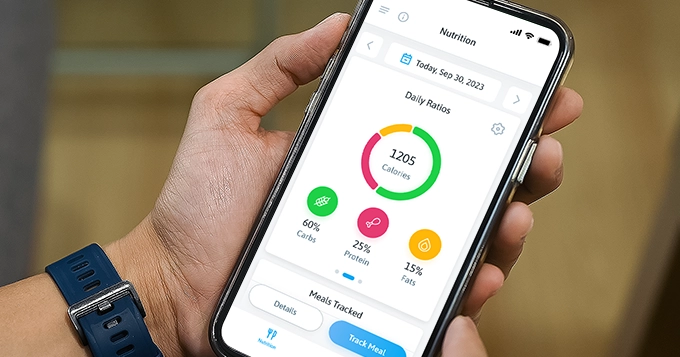 Someone holding a phone showing a fitness app interface | Trainest 