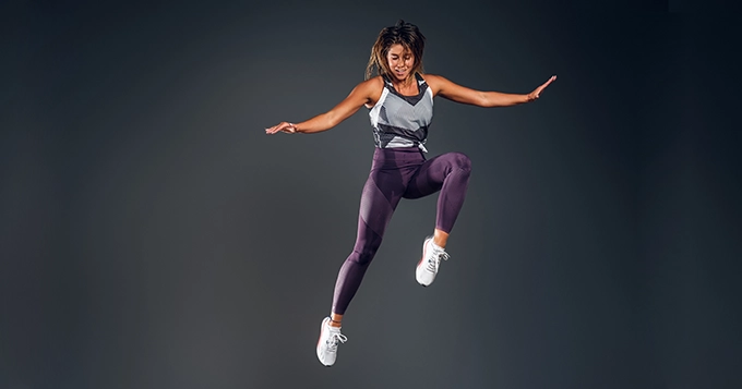 An athletic woman jumping in the air | Trainest 