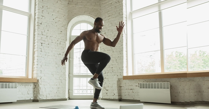 A jacked man balancing on one leg | Trainest 