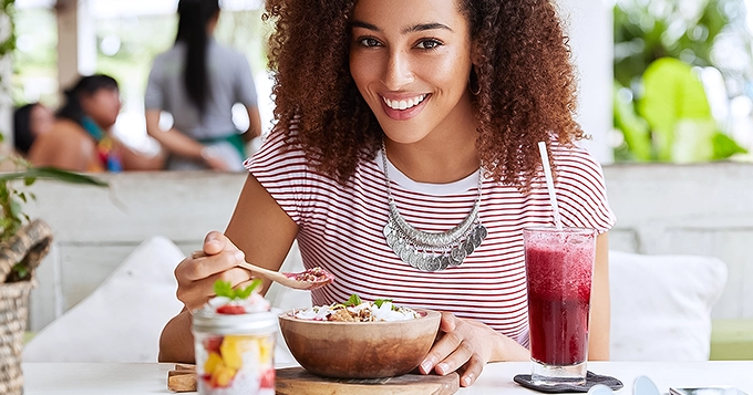 A woman eating a full meal in a restaurant | Trainest 