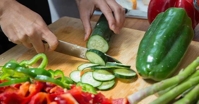 Someone slicing cucumbers and other vegetables | Trainest 