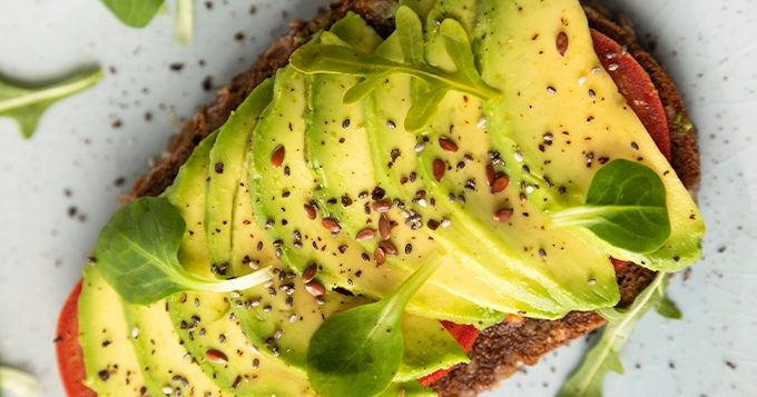 Slices of avocado topped on a piece of toast | Trainest 