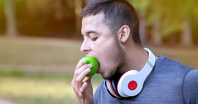 A man taking a bite out of an apple | Trainest 