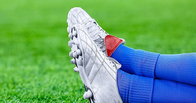 Close-up of soccer cleats in a soccer field | Trainest 