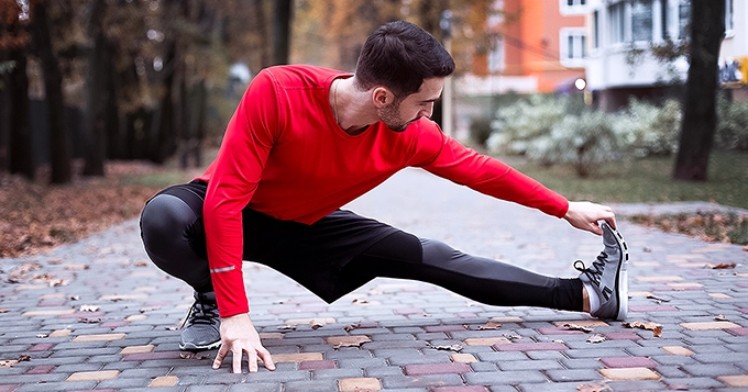 Someone doing a hamstring stretch before running | Trainest 