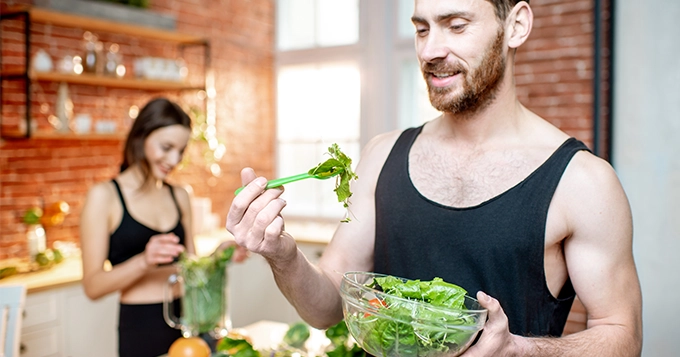 A couple preparing and eating healthy food | Trainest 