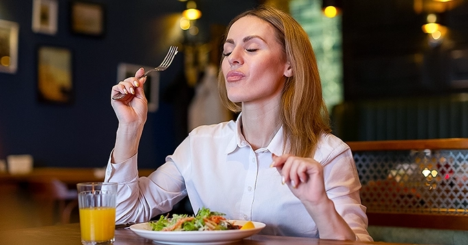 A woman savoring a healthy meal | Trainest
