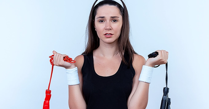 Someone looking tired or uninterested while doing jump rope exercise | Trainest