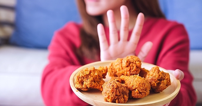 A woman pushing away a plate of food | Trainest
