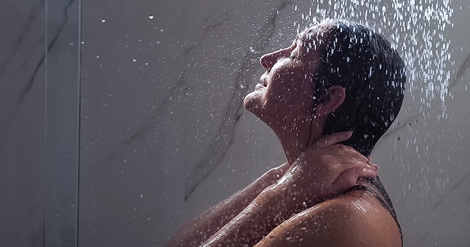 A relaxed woman taking a cold shower | Trainest