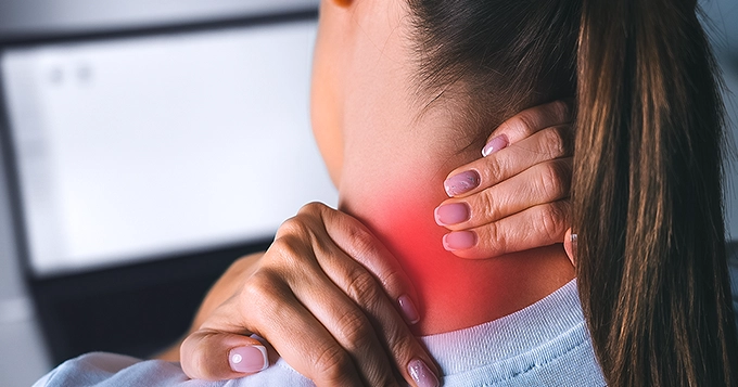 A young woman touching the back of her neck | Trainest 