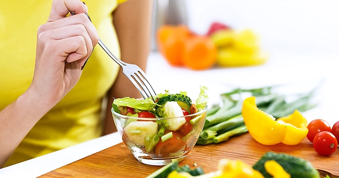 Someone enjoying a healthy bowl of salad | Trainest