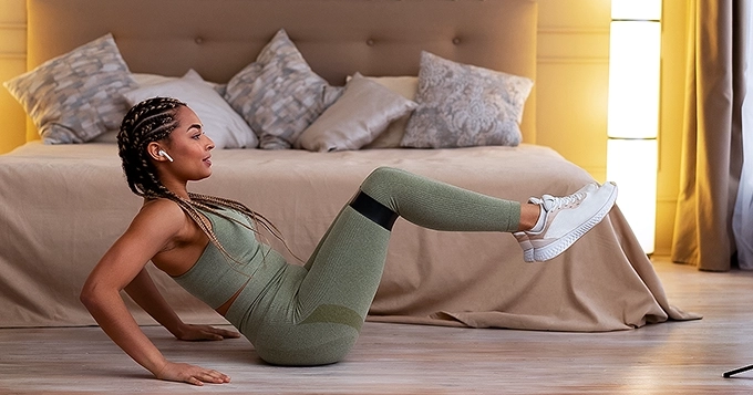 A woman exercising in the bedroom | Trainest 