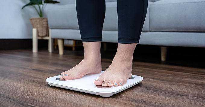 A close-up of a woman on a smart scale | Trainest
