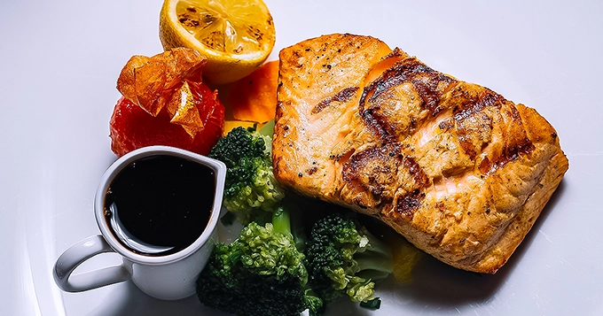 A healthy plate of roasted salmon with vegetables | Trainest
