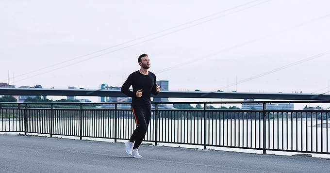 A man running on an asphalt road | Trainest