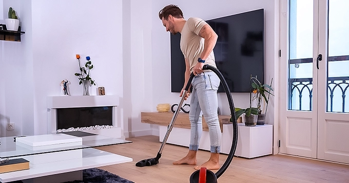 A guy vacuuming at home | Trainest