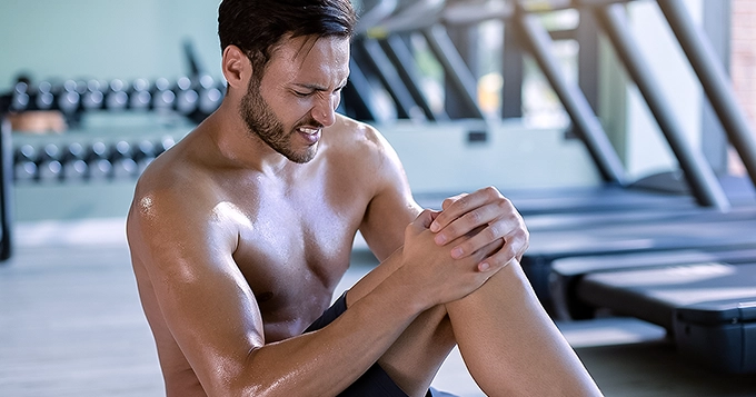 Someone suffering from a knee injury at the gym | Trainest