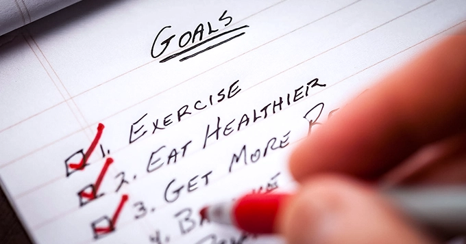 Someone ticking the boxes of their fitness goals list | Trainest
