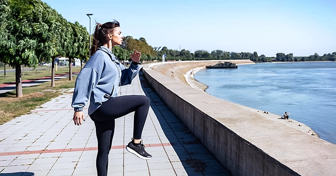 Someone doing high knees exercise outdoors | Trainest