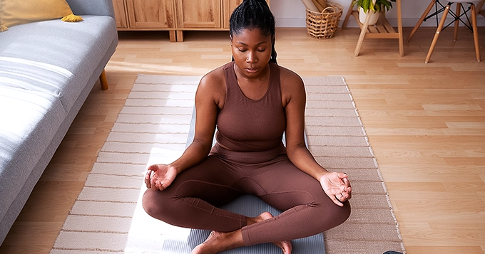 A woman meditating | Trainest