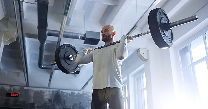 Someone doing a barbell clean exercise | Trainest
