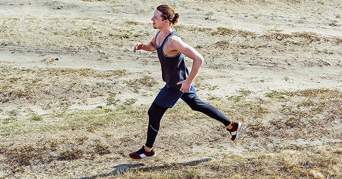 A man running on an unpaved trail | Trainest
