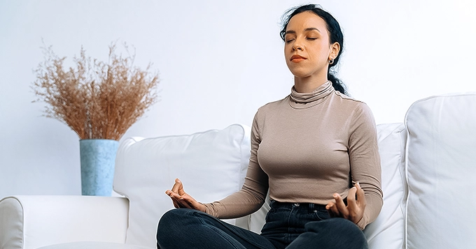 Someone meditating in the living room | Trainest
