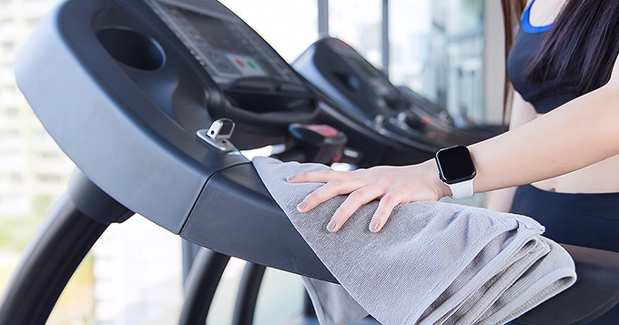 Someone running on a treadmill while wearing workout clothes and a smartwatch | Trainest