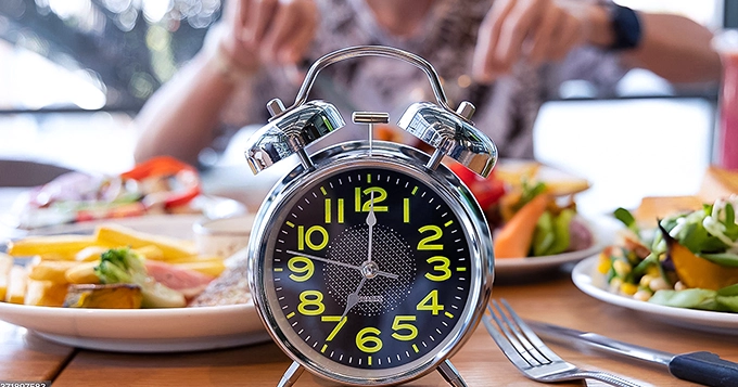 Someone eating with an alarm clock nearby | Trainest