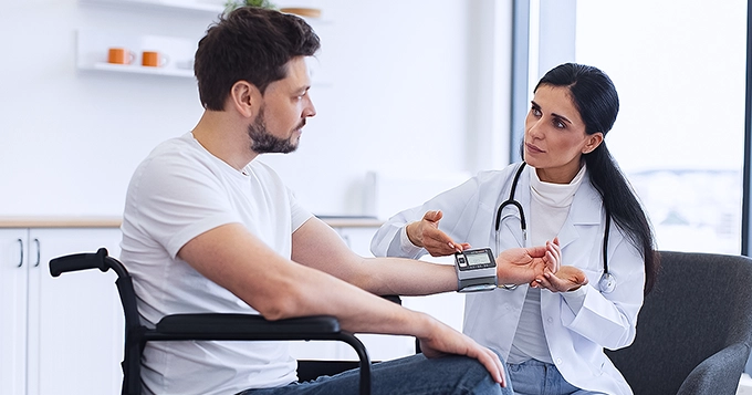 A person with a physical disability having a check-up at the doctor's office | Trainest