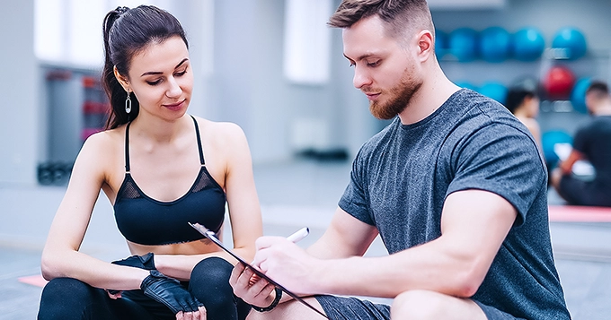 Someone talking to a fitness expert professional for an overall physique assessment | Trainest