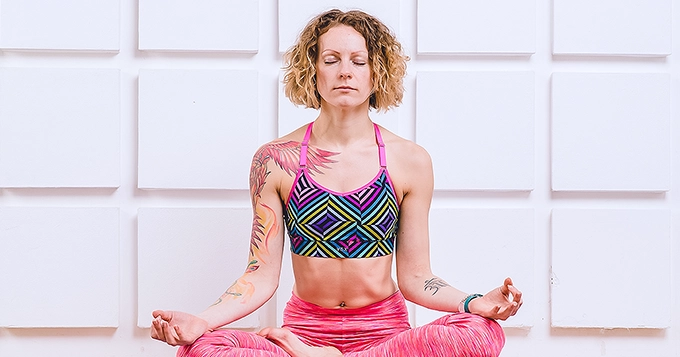 Someone wearing a vibrant-colored yoga outfit | Trainest