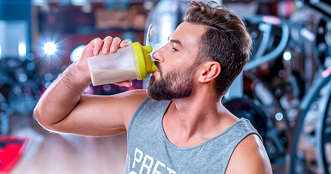 Someone drinking a protein shake | Trainest